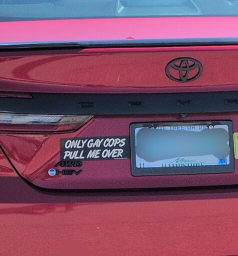 A car with a bumper sticker that says "ONLY GAY COPS PULL ME OVER"